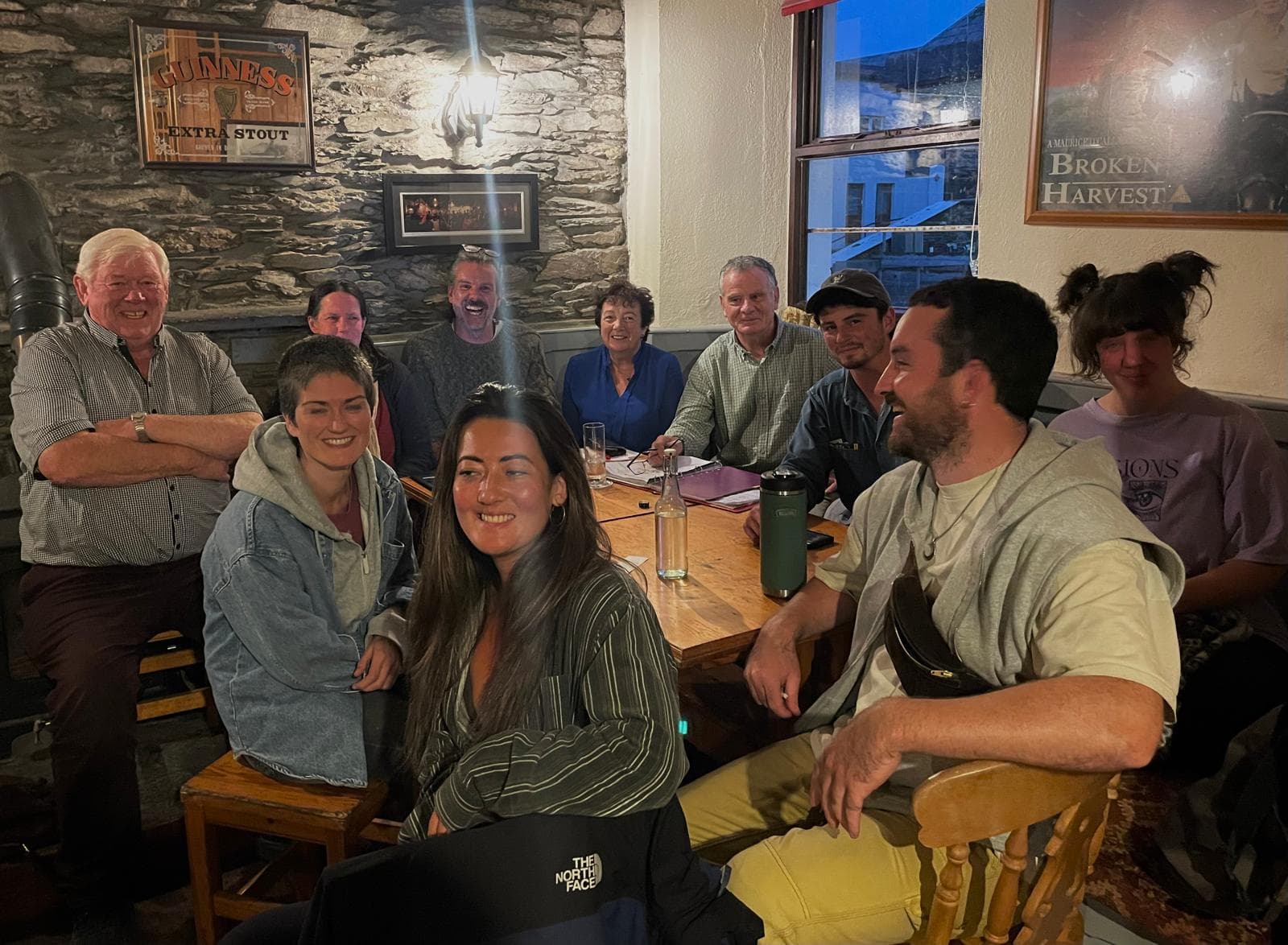 A smiling group gathered around a table in a pub with stone walls